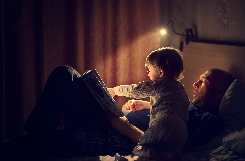 Father reading a book to his toddler on a comfortable mattress | Coir Mattress